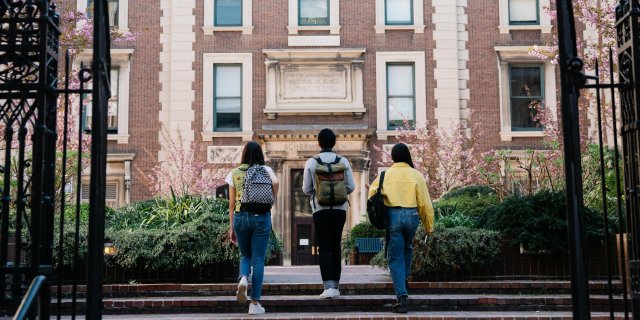 George Pak | Pexels Three students approach a university building.
