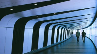 Tom Parkes | Unsplash People walking through a corridor.